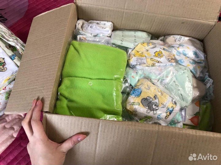 женщина упаковывает детские вещи в коробки