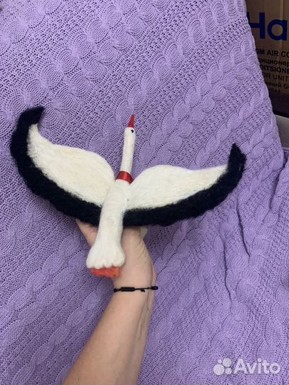 Аист с младенцем на красной ленте