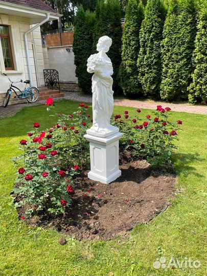 Статуя девушки из бетона с букетом