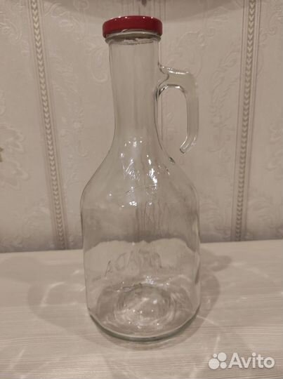 Пустая стеклянная бутылка с ручкой и крышкой