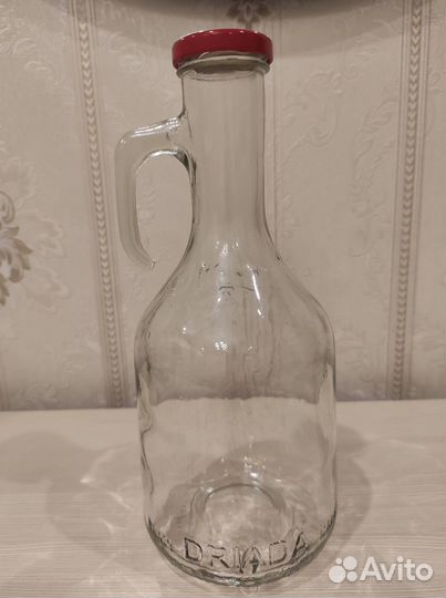 Пустая стеклянная бутылка с ручкой и крышкой