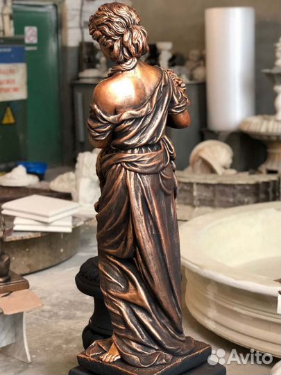 Статуя девушки из бетона с букетом