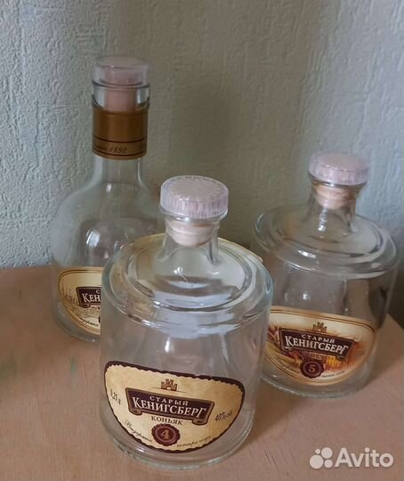 Пустые бутылки из-под коньяка в жестяной коробке