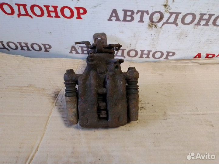 Суппорт тормозной задний левый Nissan Almera Tino