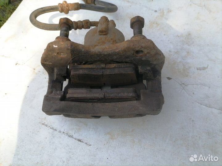 Суппорт тормозной передний левый Nissan Primera