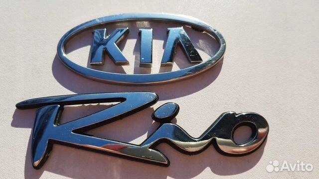 Значки киа рио 3. Эмблема Киа Рио. Кио Рио лого. Kia Rio знак. Значок машины Киа Рио.