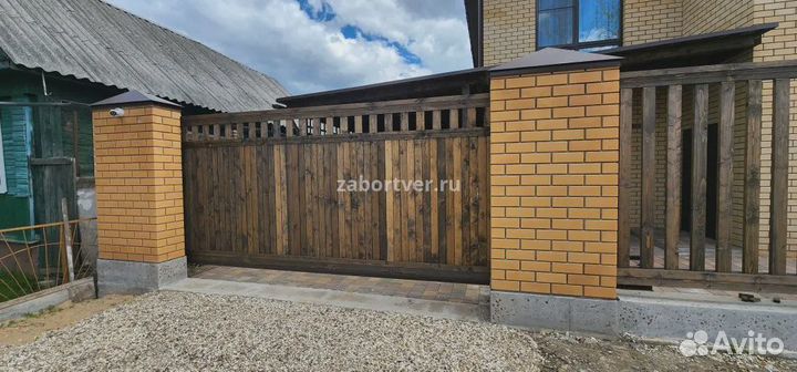 Забор из дерева с кирпичными столбами